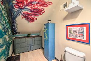 a bathroom with a toilet and a painting on the wall at Eclectic Escape with Sunroom - 2 Miles to Downtown! in Dearborn +16 photos
