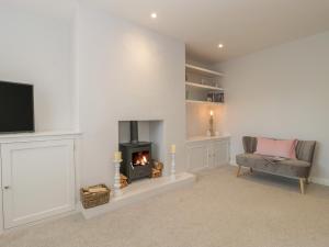 a living room with a fireplace and a chair at 1 Sutton Gate in Weymouth