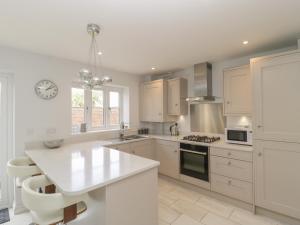 a kitchen with white cabinets and a white counter top at 1 Sutton Gate in Weymouth