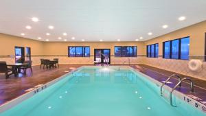 a pool in a hotel with a table and chairs at Holiday Inn Express Hotel & Suites Colby by IHG in Colby