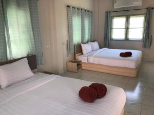 a bedroom with two beds with red towels on them at Seaside Home Khao Takiab in Hua Hin