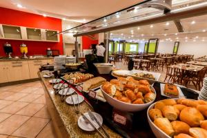 une ligne de buffet avec différents types de pains et de viennoiseries dans l'établissement Brasil Express, à Balneário Camboriú