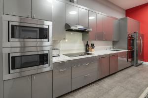 una cucina con elettrodomestici in acciaio inossidabile e pareti rosse di The Dorel SF a San Francisco Altre 32 foto