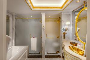 a bathroom with a tub and a shower and a sink at Dalat Palace Heritage Hotel in Da Lat