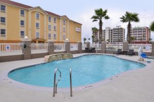 Una piscina con sillas y un edificio. en Holiday Inn Express & Suites Corpus Christi-N Padre Island by IHG, en Corpus Christi