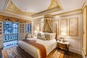a bedroom with a king sized bed with ornate ceilings at Dalat Palace Heritage Hotel in Da Lat