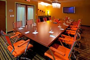 Holiday Inn Hotel & Suites Ocala Conference Center, an IHG Hotel في أوكالا: قاعة اجتماعات كبيرة مع طاولة وكراسي طويلة