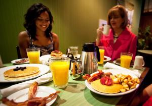 two women sitting at a table with breakfast food at Holiday Inn Hotel & Suites Ocala Conference Center by IHG in Ocala
