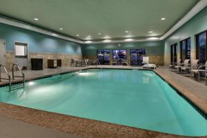 a pool in a hotel room with a waiting area and chairs at Holiday Inn Express Hotel & Suites Cedar Rapids I-380 at 33rd Avenue, an IHG Hotel in Cedar Rapids
