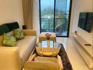 - un salon avec un canapé et une table en verre dans l'établissement Cassia Apartment 1, à Bang Tao Beach