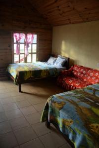 1 dormitorio con 2 camas y ventana en Cabañas Paraiso tziscao en Comitán de Domínguez