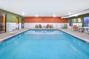 - une piscine avec des chaises et des tables dans une chambre d'hôtel dans l'établissement Holiday Inn Express Hotel & Suites Circleville, an IHG Hotel, à Circleville