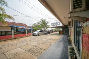 una calle con coches estacionados en el lateral de un edificio en OYO 1273 Hotel Belvena, en Palembang