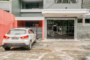 un coche blanco estacionado frente a un edificio en RedDoorz near Plaza Senayan en Yakarta