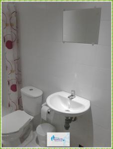 a white bathroom with a toilet and a sink at HOTEL CASA GARCES in Cartagena de Indias