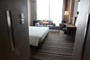 a hotel room with a bed and a couch at Novotel Bangkok IMPACT in Nonthaburi