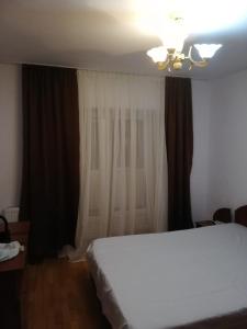 a bedroom with a white bed and a window at Apartament Central Vatra Dornei in Vatra Dornei