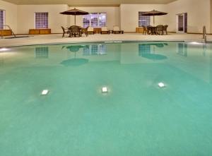 a large pool with blue water in a hotel at Holiday Inn Express Hotel & Suites Council Bluffs - Convention Center Area by IHG in Council Bluffs