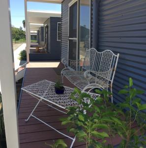 eine Terrasse mit 2 Stühlen und einem Tisch auf einem Haus in der Unterkunft Terminus Hotel in Coonamble