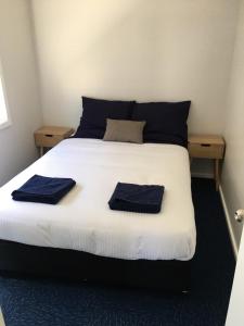 a bed with two blue towels on top of it at Terminus Hotel in Coonamble