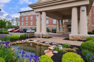 einen Garten mit einem Teich vor einem Gebäude in der Unterkunft Holiday Inn Express Hotel & Suites Cincinnati - Mason, an IHG Hotel in Mason