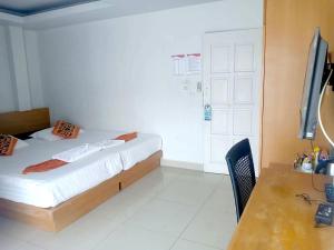 a bedroom with a bed and a desk and a television at PKL Residence in Patong Beach