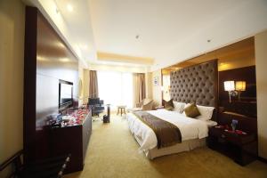 a hotel room with a large bed and a television at Foshan Royal Prince Hotel in Shunde