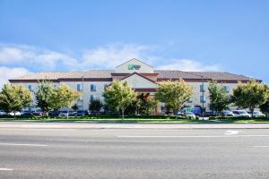 um grande edifício ao lado de uma estrada em Holiday Inn Express & Suites Clovis Fresno Area, an IHG Hotel em Clovis