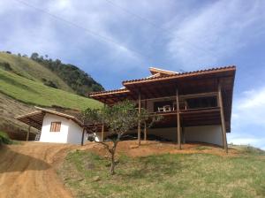 a house on a dirt road next to a hill at Casa Cleo - Somente carro 4x4 ou fazemos translado sem custo in São Francisco Xavier
