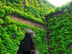 a building covered in green ivy with a sign on it at Kurashiki Ivy Square in Kurashiki