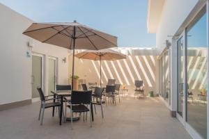 a patio with tables and chairs and umbrellas at Holiday Inn Express & Suites Silao Aeropuerto Terminal by IHG in Silao