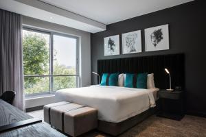 um quarto com uma cama grande e uma janela grande em The Capital Empire em Joanesburgo