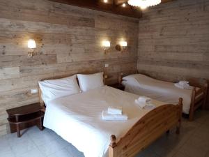 2 camas en una habitación con paredes de madera en Agriturismo Cornolade, en Ponte nellʼAlpi