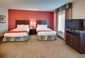 a hotel room with two beds and a flat screen tv at Holiday Inn Express Hotel & Suites Pleasant Prairie-Kenosha, an IHG Hotel in Pleasant Prairie