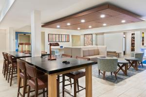 a living room with a large table and chairs at Holiday Inn Express & Suites - Columbus Airport East by IHG in Columbus