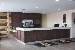a lobby with a reception counter with mats on the floor at Super 8 by Wyndham Spruce Grove in Spruce Grove +37 photos