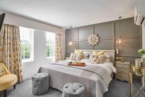 una camera con un grande letto e una sedia di Burnham Beeches Hotel a Slough