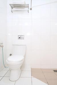 a white bathroom with a toilet and a shower at Houz Inn in Bintulu