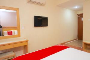 a bedroom with a bed and a tv on the wall at Houz Inn in Bintulu +26 photos