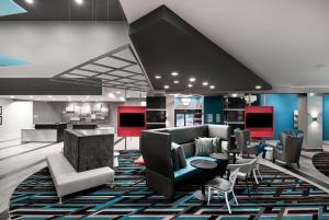 Holiday Inn Express & Suites - Charlotte Airport, an IHG Hotel في تشارلوت: لوبي فيه كنب وكراسي وطاولات