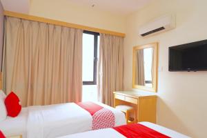 a hotel room with two beds and a television at Houz Inn in Bintulu