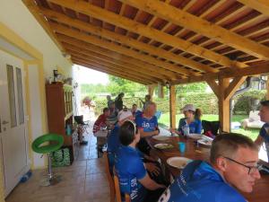 un grupo de personas sentadas alrededor de una mesa de madera en Mill House Apartment and Camping, en Ljutomer