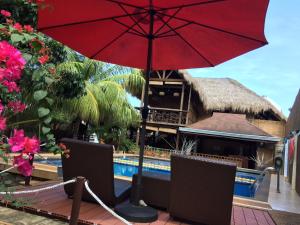 a red umbrella and chairs next to a pool at Palms Cove Resort in Panglao Island