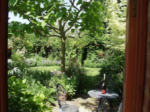 uma mesa e cadeiras num jardim com uma árvore em Leadon House Hotel em Ledbury