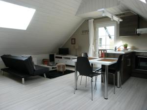 a kitchen and living room with a table and chairs at Espace Bien Etre et Spa in Libin