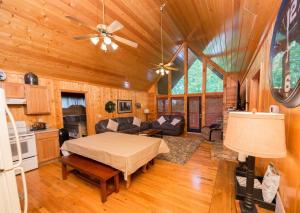 a living room with a bed and a kitchen at Drift Away Cabin in Sevierville