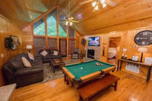 a living room with a pool table in a cabin at Drift Away Cabin in Sevierville