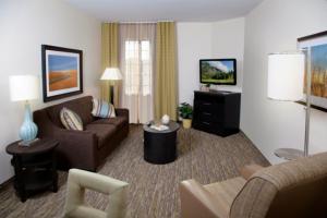sala de estar con sofá y TV en Candlewood Suites - Topeka West, an IHG Hotel, en Topeka