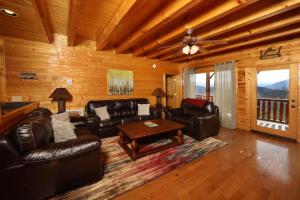 a living room with leather furniture in a cabin at Ridgetop Theatre Lodge Cabin in Park Settlement +50 photos