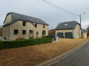 a brick house with a car parked in front of it at Espace Bien Etre et Spa in Libin